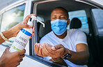 Covid, sanitiser and drive thru service for clients at testing centre or station for coronavirus. African man driving his car and wearing protective face mask to avoid contact with medical worker