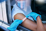 Closeup of man getting corona vaccine at a modern drive thru station with a health care professional. Nurse applying plaster after injection, treatment or booster shot, staying safe  from illness 