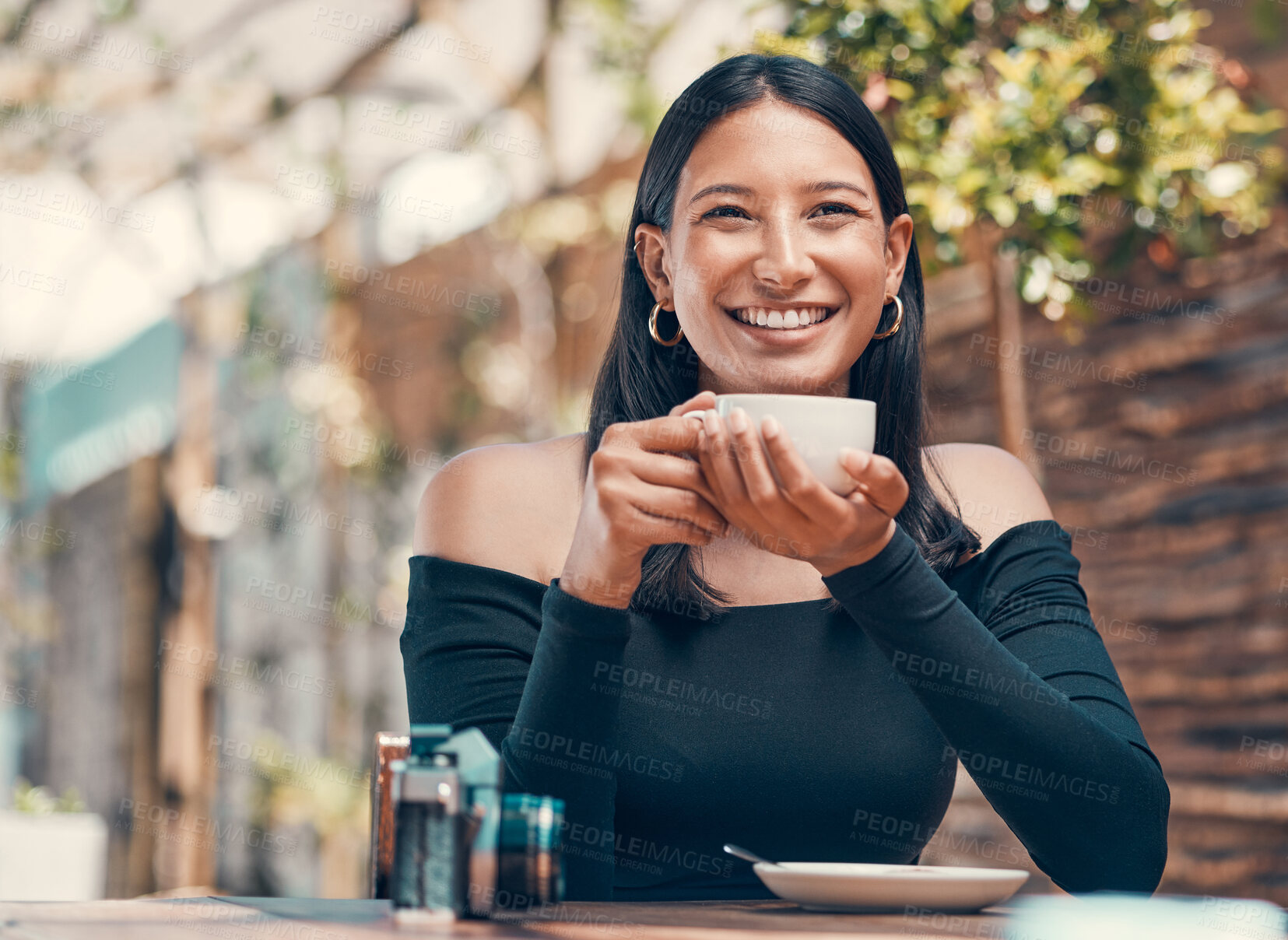 Buy stock photo Relaxed, happy, and calm woman drinking a cup of tea at an outdoor coffee shop. Beautiful and attractive young female holding a hot beverage at a cafe in the morning. Lady with a warm mug in hand