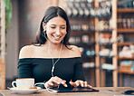 Beautiful, happy and relaxed student reading on tablet while listening to podcast, education video or music in cafe. Smiling woman browsing online and watching distance learning webinar in restaurant