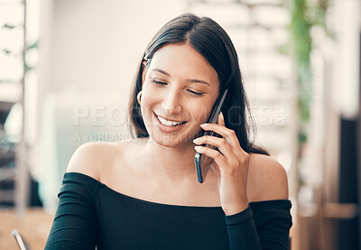 Beautiful, young and friendly woman talking on the phone sitting alone at a coffee shop. Confident female flirting and smiling on call outside a restaurant on a summer weekend