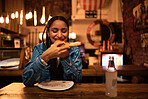 Pizza, food and restaurant where young woman is eating food and enjoying alcohol drink. Hungry female having delicious meal at bar at night. Happy  and satisfied foodie having tasty supper at a diner 