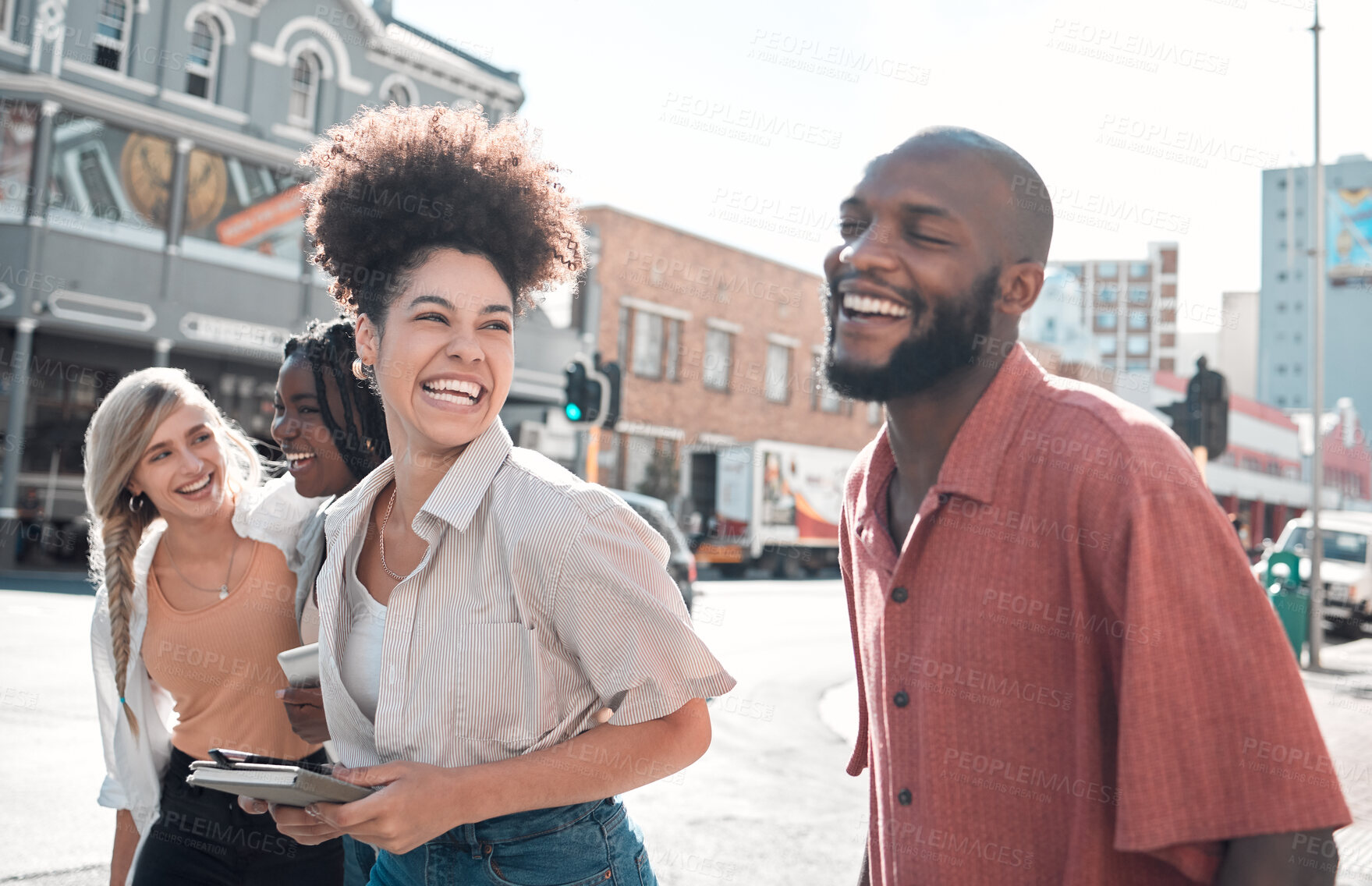 Buy stock photo Happy, laughing group of friends walking and smiling together in a city. Casual excited people enjoying a relaxing time in an urban town. Cheerful young coworkers having fun on their day off.