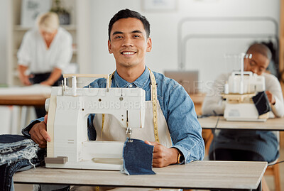 Young adult fashion designer in sewing workshop. Professional man in clothing and material design at work with diverse group of employees. Creative, innovative working guy at a desk in the workplace.