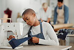 Fashion, design and creative work at a workshop. Young african American factory worker sewing new, trendy, fashionable clothing of the season. Black female working on a machine in a busy workplace