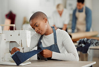 Buy stock photo Fashion, design and creative work at a workshop. Young african American factory worker sewing new, trendy, fashionable clothing of the season. Black female working on a machine in a busy workplace