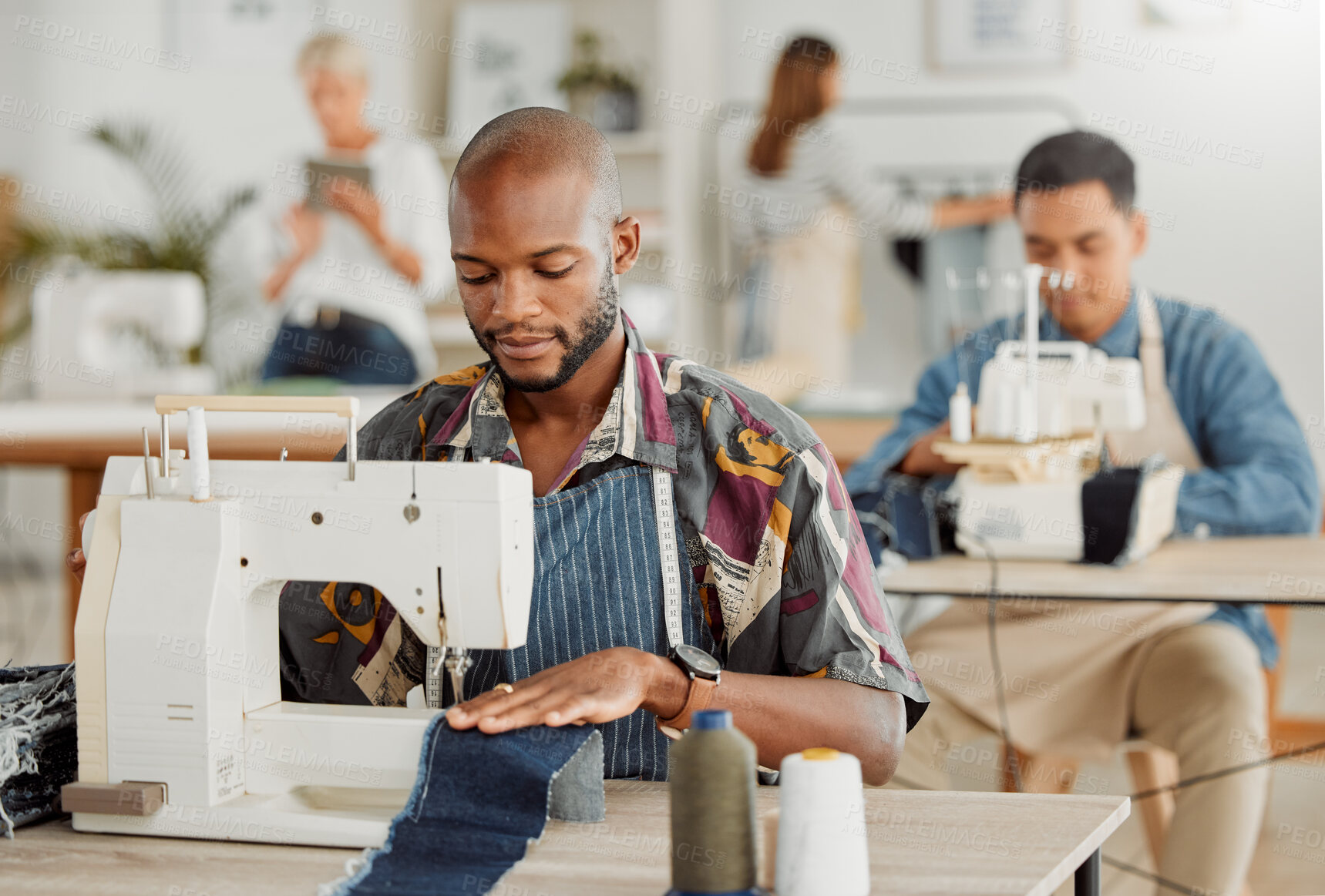 Buy stock photo Fashion, design and stylist or a young designer working with sewing machine. Busy, creative business employee creating new, trendy and fashionable clothes. Man at work with material in a workshop.
