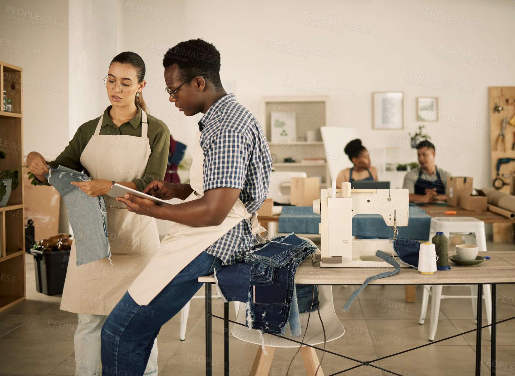 Buy stock photo Clothes, clothing and fashion designers working on new trendy jean designs at a denim workshop. Ambitious, young and creative people in a startup business discussing patterns and styles before sewing