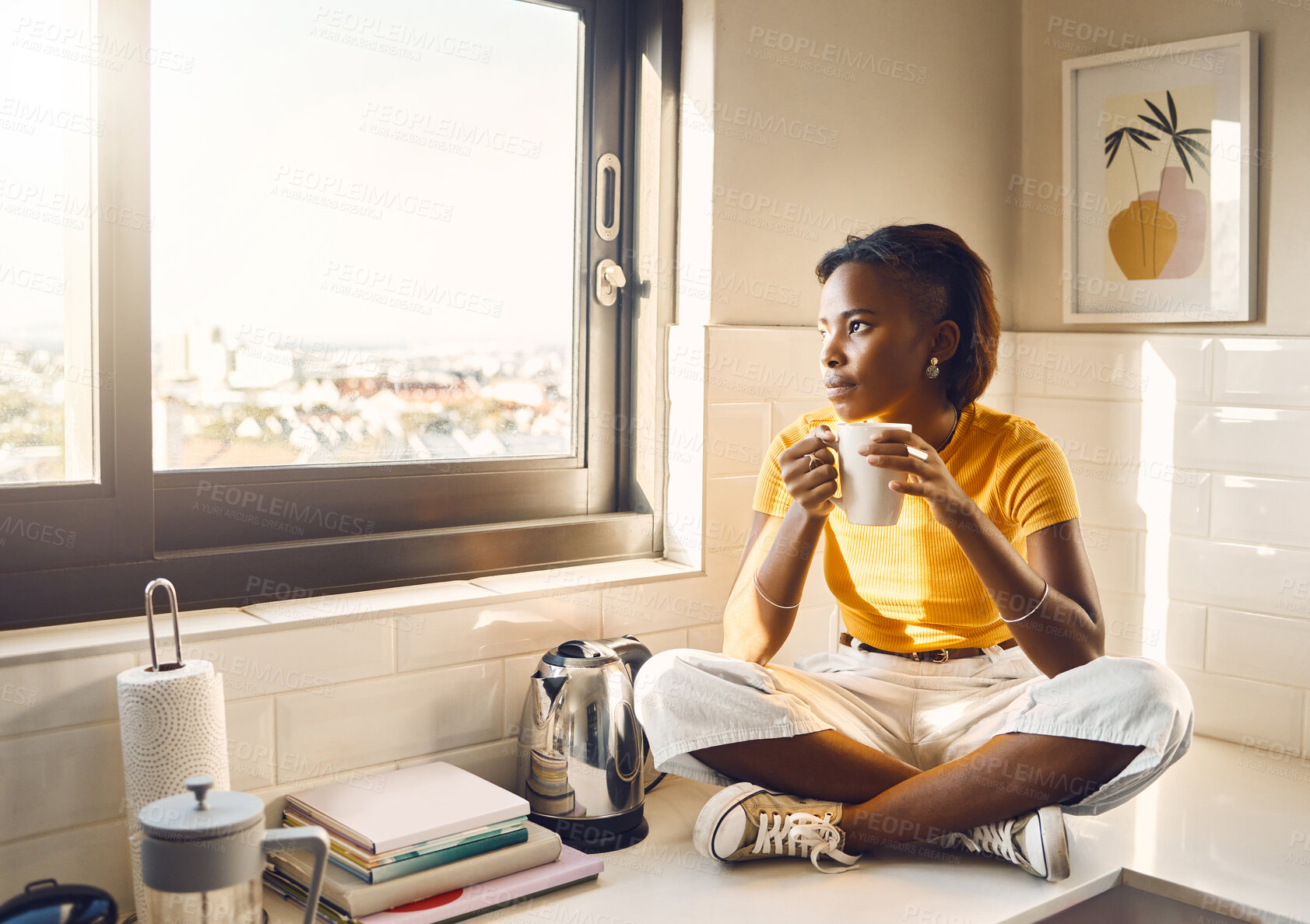 Buy stock photo Thinking, serious and African woman drinking coffee while sitting on the kitchen counter alone at home. One content, carefree and peaceful black female enjoying a cup of tea while looking thoughtful