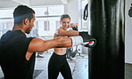 Serious and fit man and woman looking active, fit and sporty while training together for fitness at the gym. Young couple boxing, exercising and doing a routine cardio workout at a sports center 