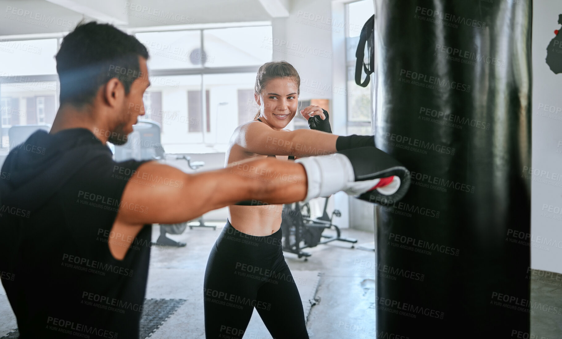Buy stock photo Active and fit man and woman boxing, exercising and training together for fitness at the gym. Young, sporty and serious couple doing a routine cardio workout and working out at a sports center 