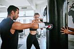 Healthy, fit and active female boxer training, exercising and sparring with her coach, trainer or instructor in the gym or health club. Young woman preparing for a boxing fight, match or competition