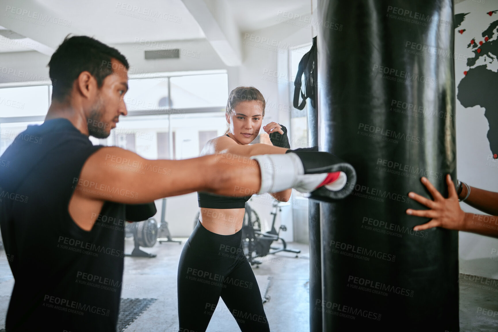 Buy stock photo Healthy, fit and active woman boxing, training and exercising with her coach, trainer or instructor in the gym or health club. Young female boxer preparing for a fight, match or sports competition