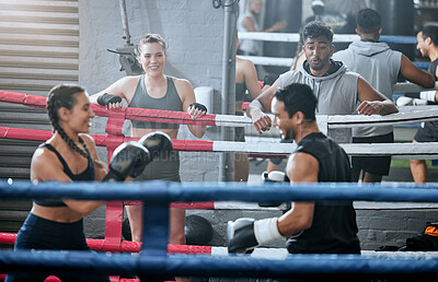 Active, healthy and fit diverse boxing group training and working out together in a gym. Sports group doing a strength fight exercise while people watch. Smiling fitness team in a friendly workout
