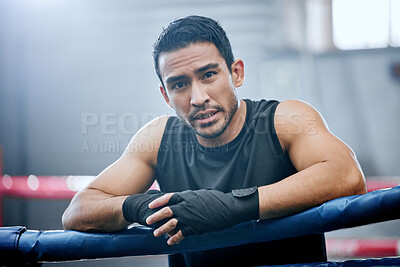 Buy stock photo Young, fit and active man boxing, sweating and breathing heavily after training and exercising at gym. Portrait of a sporty, serious and sweaty male athlete taking a break from a cardio workout