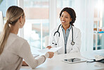 Doctor and patient discuss paperwork during medical consultation in a hospital. Healthcare professional, GP or physician prepare insurance document and checking personal information at a clinic