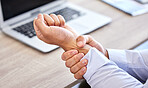 Business man with bad wrist pain in the hand after an injury and ache while in the office. Closeup of a corporate male with a painful strain, hurtful and sore sitting at his desk
