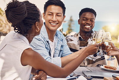 Buy stock photo Diverse group toasting and celebrating friendship at an outdoor restaurant, having fun and laughing. Happy people cheers while bonding, talking and enjoying a celebration of good, exciting news 