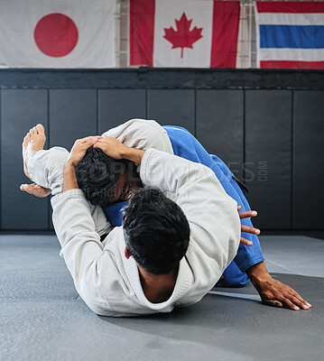 Buy stock photo Male martial arts, fighting at a dojo and holding his opponent. Karate, sports and taekwondo adults training at the gym for a fight. Athlete, aikido and practicing for an international competition.