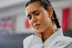 Sports injury, closeup and pain in neck at martial arts practice. Mma fitness studio woman injured while training at the dojo. Face of karate student and fighter at gym hurt in training.
