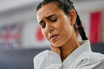 Sports injury, closeup and pain in neck at martial arts practice. Mma fitness studio woman injured while training at the dojo. Face of karate student and fighter at gym hurt in training.
