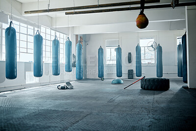 Buy stock photo Empty boxing, health and fitness gym with workout, training and exercise equipment. A fight club, wellness or sports room full of punching bags for industry professional athlete, expert or trainer