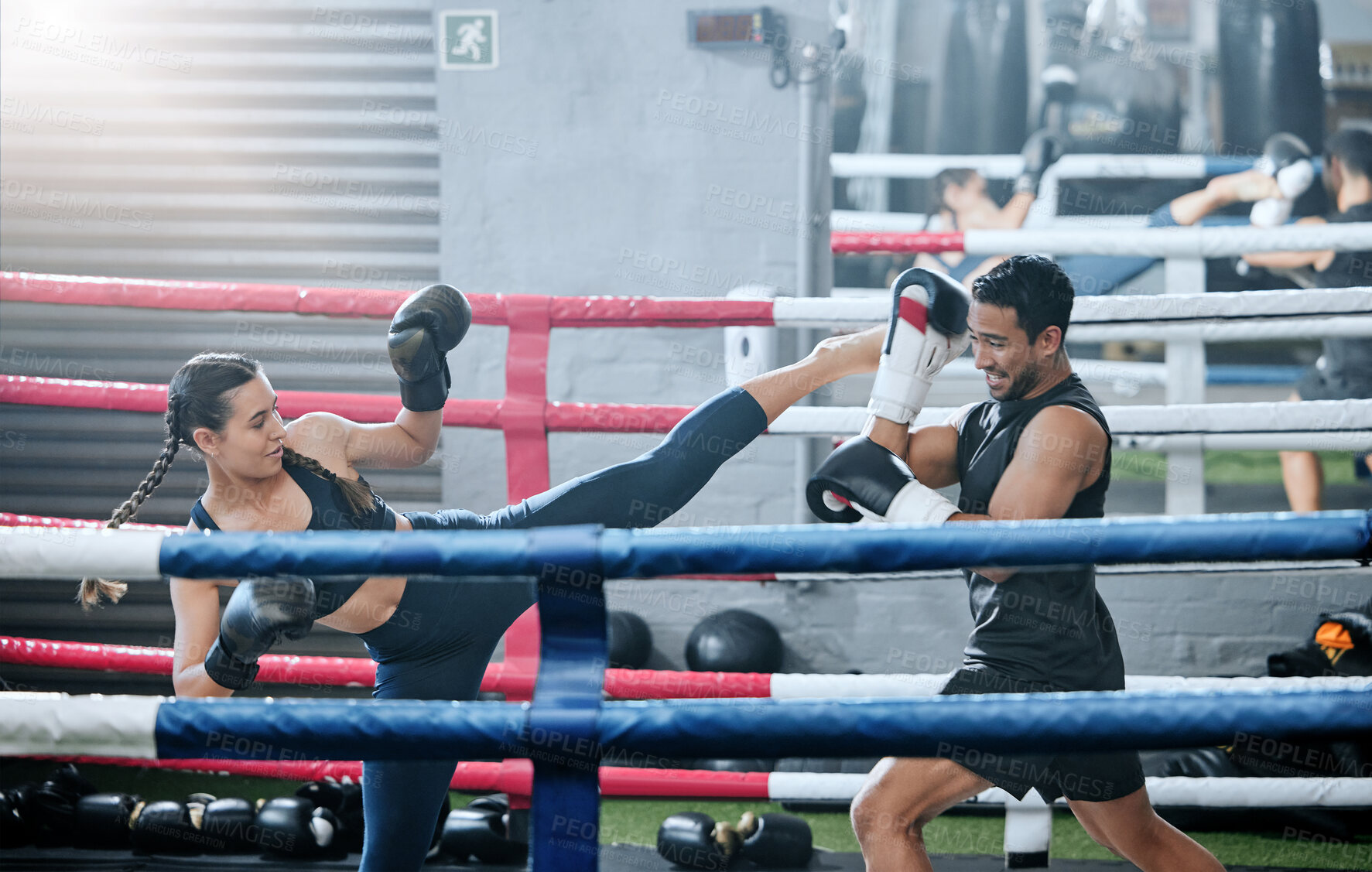 Buy stock photo Fit, active and healthy kickboxing athletes exercise training together in boxing ring in modern sports gym. Sporty and strong woman workout with her fitness coach trainer together in fighting studio