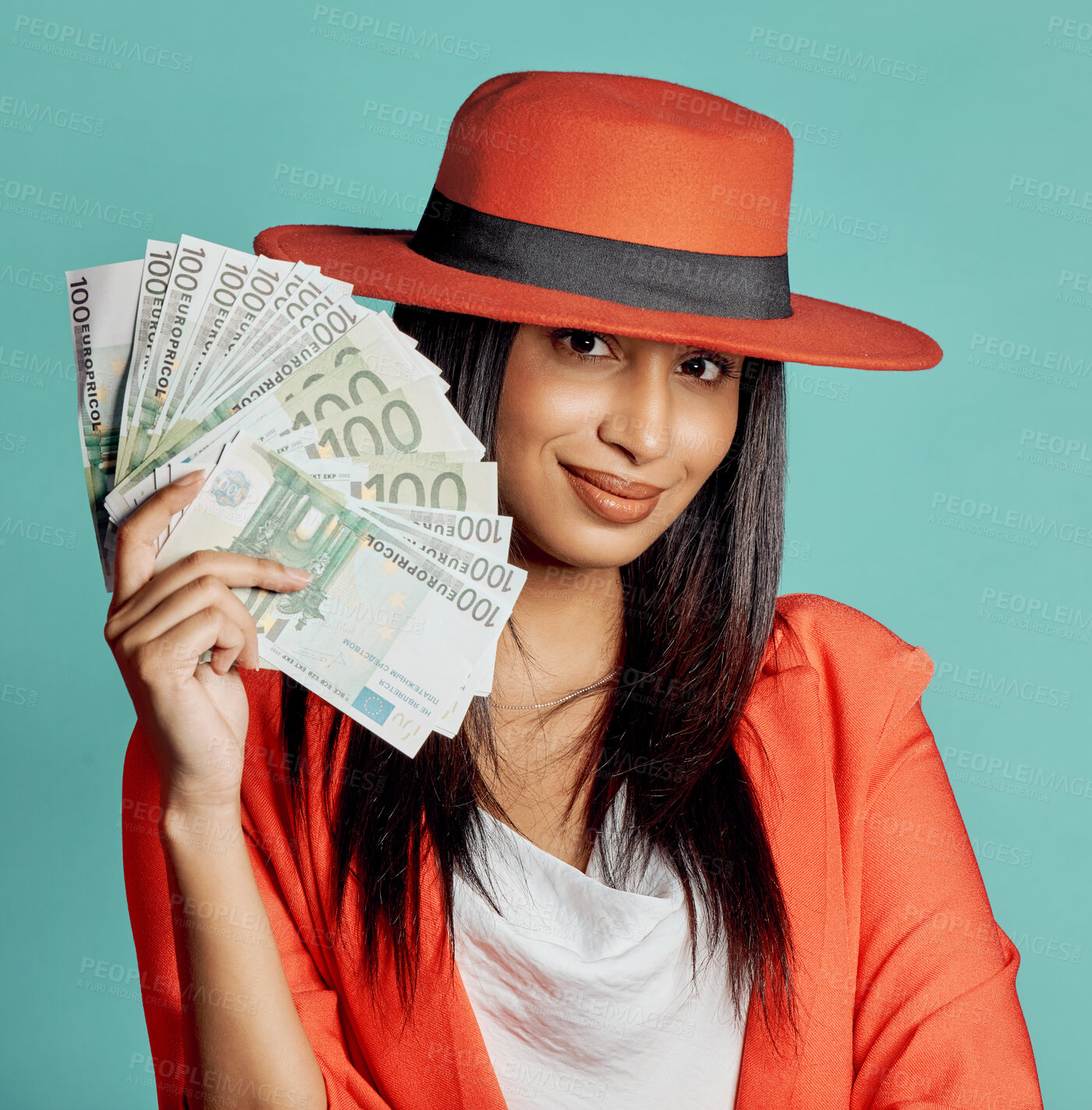 Buy stock photo Rich, successful and wealthy young woman holding cash money after winning competition, lottery or casino prize. Smiling, elegant and trendy female with pay reward against a blue studio background   