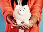 Closeup of a stylish, trendy and elegant female hands holding a piggy bank with her savings. Woman with future planning financial investments and looking after her wealth growth developments. 
