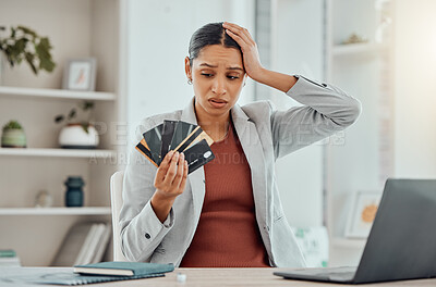 Buy stock photo Financial stress, concerned and frustrated woman holding bank cards in her hand at her desk. Business female worried about economic decisions, credit interest or loan and debt in money crisis.
