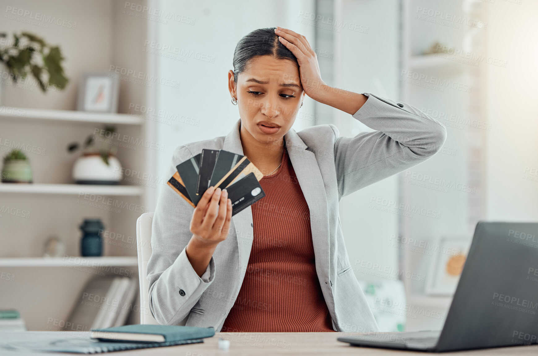 Buy stock photo Financial stress, concerned and frustrated woman holding bank cards in her hand at her desk. Business female worried about economic decisions, credit interest or loan and debt in money crisis.