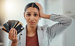 Financially stressed, concerned and frustrated woman holds bank cards in her hand. Economic decisions, expense inflation and business debt for financial analyst. Close shot of worrying female. 