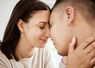 Buy stock photo Affectionate, loving and happy couple faces together and relaxing at home enjoying quality time. Loving and romantic lovers bonding and cuddling in the house expressing feelings of love