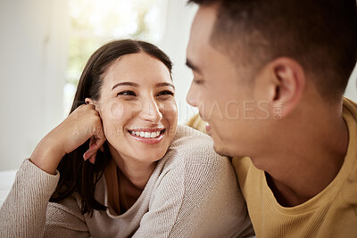 Buy stock photo Happy, carefree and smiling couple relaxing together at home and spending quality time. Relaxed, loving and excited lovers having fun and cuddling in the house enjoying being affectionate