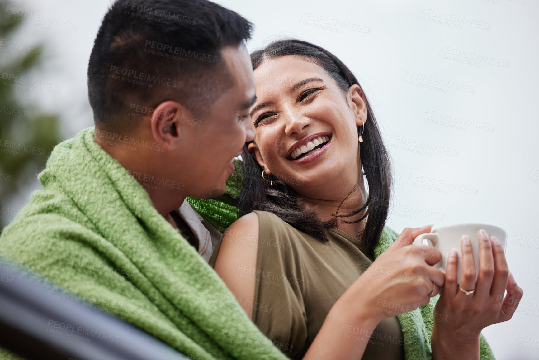 Buy stock photo Cozy, smiling and romantic young couple cuddling and relaxing with blanket in cold winter. Loving husband and wife laughing and enjoying dating relationship bonding time in outdoors nature