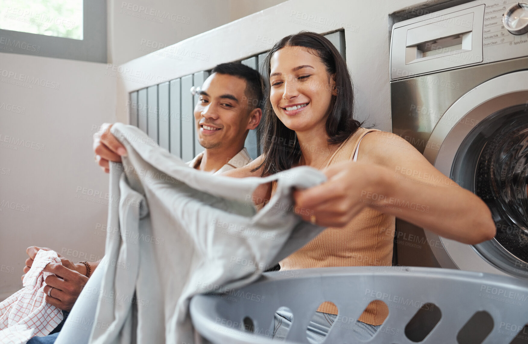 Buy stock photo Folding laundry, day chores and house work of a happy, smiling and positive couple cleaning. Sitting, cheerful and loving partners washing clothes and working together on a relaxed day at home inside