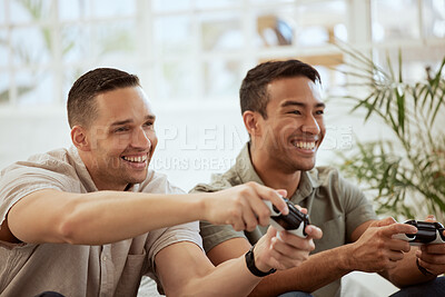 Buy stock photo Smiling male friends playing video game console and having fun, hanging out together at home. Young men holding joystick controllers being playful and enjoying their free leisure break time 