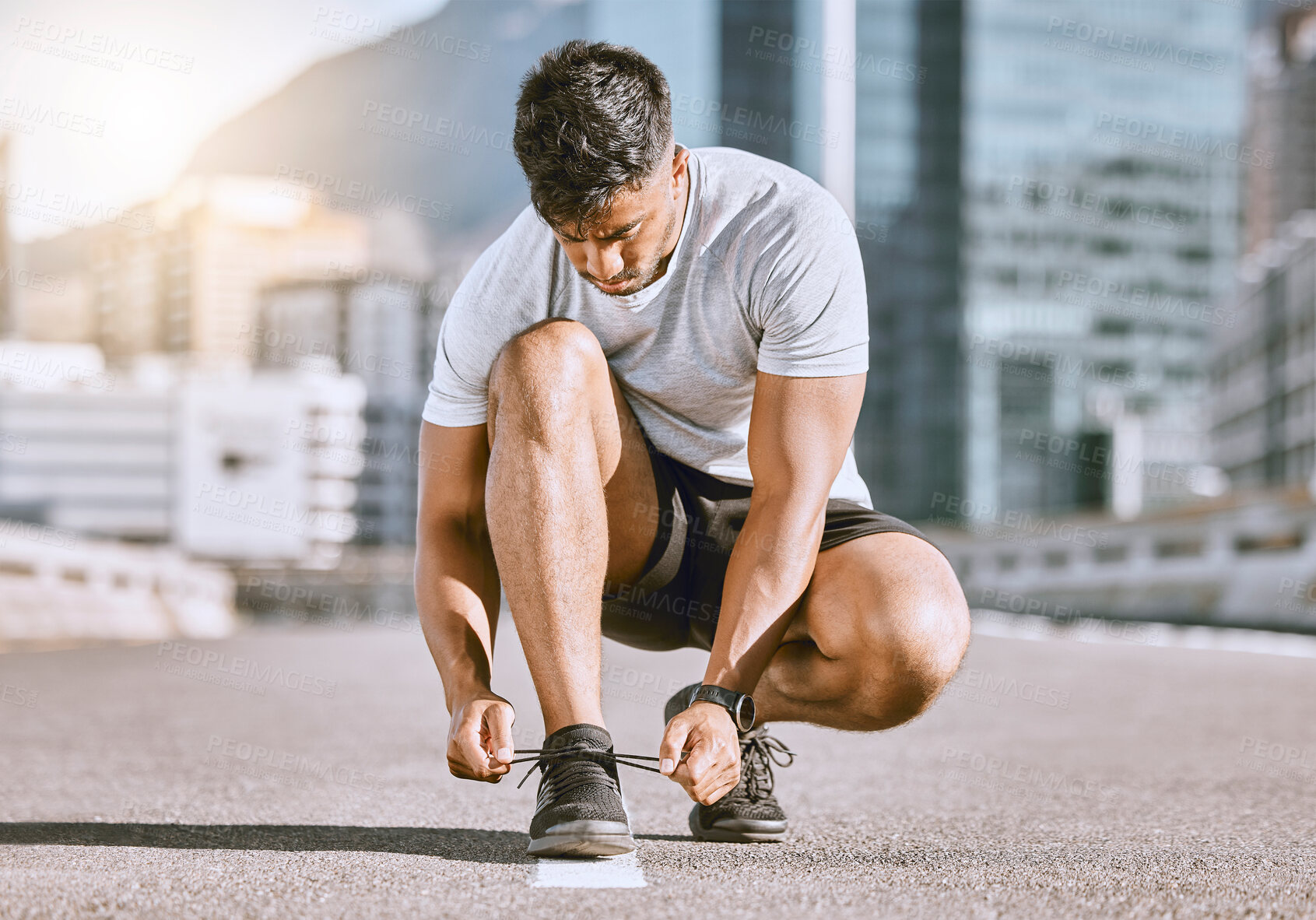 Buy stock photo Wellness and fitness runner ties shoes lace before running in a city street during summer. Healthy man athlete prepare sneaker for a comfortable fit for a sport exercise, training or marathon workout