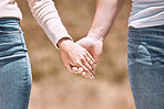 Couple holding hands, love and care showing affection, friendship and romance while on a walk together in nature. Closeup of boyfriend and girlfriend expressing loving, caring and comforting emotion 