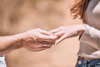 Buy stock photo Engagement, proposal and romance while putting a ring on the finger of a woman saying yes to marriage outside. Closeup hands of a young couple telling you to save the date for their wedding day