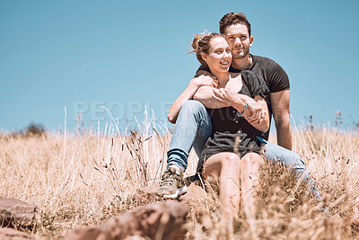 Buy stock photo Carefree, smiling and relaxed couple bonding, having fun and looking at the view while sitting on the grass in a nature park together. Loving, caring and romantic boyfriend and girlfriend hugging
