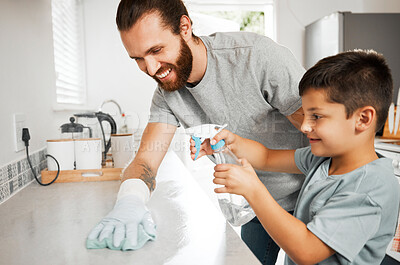 Cleaning, bonding and caucasian father and son working together to keep the home tidy. Chores, learning and a happy childhood with dad spending quality time with his boy as they clean the kitchen.