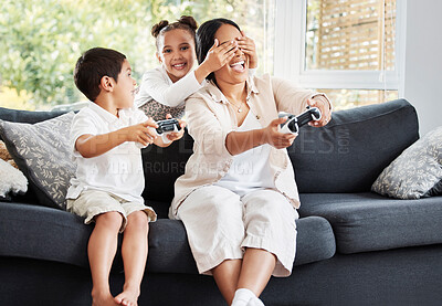 Buy stock photo Family, video games and cheating little girl covering her mother's eyes to let her brother win on the couch at home. Entertainment, joystick and having fun while enjoying a bonding activity with kids