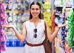Shopping, retail and consumerism with a female customer standing in a grocery store, shop or supermarket aisle. Portrait of a young woman gesturing with products packed on shelves in the background