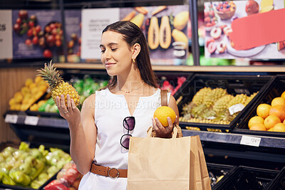 Buy stock photo Shopping, holding and looking at fruit at shop, buying healthy food and examining items at a grocery store. Woman deciding, choosing and picking ripe, fresh and delicious produce at a market