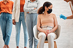Covid vaccination, virus and vaccine needle flu shot with people in line at clinic facility for protection, or prevention of diseases. A woman wearing surgical face mask for employee business policy