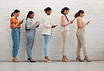 Diverse, creative and professional women on phone browsing the internet or social media. Group of students standing while scrolling online with technology. Multiracial females waiting for interview.