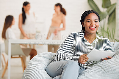 Buy stock photo Creative black woman on social media, with tablet and checking online while on a work break. Happy young lady boss of ecommerce startup, relaxing before a business meeting business with her girl team