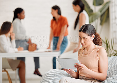 Buy stock photo Business woman browsing the internet or social media on a tablet while sitting and relaxing on a break. Serious and young digital marketing agency employee typing an online proposal on the internet