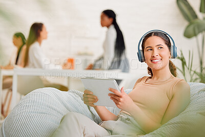 Buy stock photo Thinking, idea and wondering female employee sitting and browsing on a tablet and headphones on a break in an office. Happy female marketing agency worker looking in the distance searching online